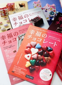 木野内さんがこれまで編集した通販カタログ「幸福のチョコレート」。手前の２０２１年版の表紙を飾るのは、特注し、集めたハートチョコ（撮影・辰巳直之）