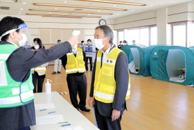 新型コロナウイルス感染症対策の避難所運営訓練で、非接触型体温計の使い方を確認する高砂市職員たち＝高砂市荒井町千鳥２、高砂市役所南庁舎