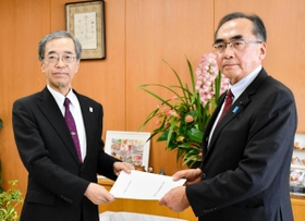 自民党兵庫県議団の藤本百男幹事長（右）から立候補の要請書を受け取る金沢和夫副知事＝２５日午後、兵庫県庁