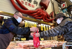 コロナ禍に負けず笑顔で接客する商店街の人たち。週末も重なり多くの人でにぎわった＝２７日午後、明石市本町、魚の棚商店街（撮影・秋山亮太）
