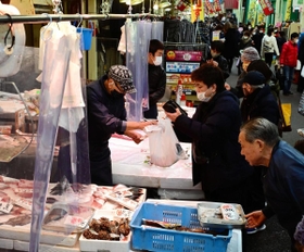 新年の装いが施された東山商店街で有頭エビなどを買い求める人々。まだ人出は少なめで、にらみ鯛などが並ぶ２９日以降になるとにぎわいが本格化するという＝２７日午後、神戸市兵庫区の東山市場（撮影・中西幸大）