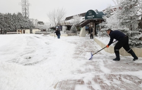 観光客の通路を雪かきする人たち＝３１日午前、神戸市灘区六甲山町（撮影・吉田敦史）