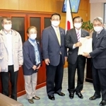 山本博司厚生労働副大臣（右から３人目）に要望書を手渡す支援団体関係者ら＝厚労省