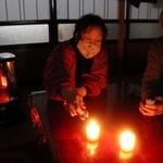 停電のため、ろうそくで明かりを確保する西村行雄さん夫妻＝１７日午後、兵庫県新温泉町歌長