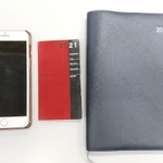 スマートフォンより小さい部長の手帳（左）とＡ５サイズの次長の手帳（右）