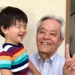 孫を抱く横野浩一さん（遺族提供）