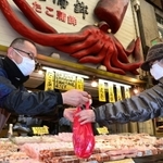 コロナ禍に負けず笑顔で接客する商店街の人たち。週末も重なり多くの人でにぎわった＝２７日午後、明石市本町、魚の棚商店街（撮影・秋山亮太）