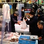 新年の装いが施された東山商店街で有頭エビなどを買い求める人々。まだ人出は少なめで、にらみ鯛などが並ぶ２９日以降になるとにぎわいが本格化するという＝２７日午後、神戸市兵庫区の東山市場（撮影・中西幸大）