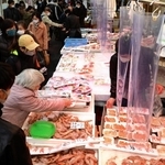 新年の装いが施された東山商店街で有頭エビなどを買い求める人々。まだ人出は少なめで、にらみ鯛などが並ぶ２９日以降になるとにぎわいが本格化するという＝２７日午後、神戸市兵庫区の東山市場（撮影・中西幸大）