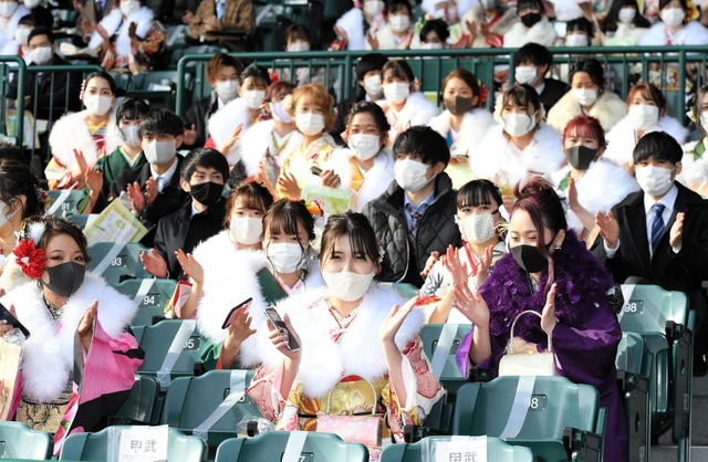 昨年に続き、甲子園球場が会場となった西宮市の成人式。１席ずつ空けて着席した新成人が三本締めをした＝１１日午後、西宮市甲子園町（撮影・後藤亮平）