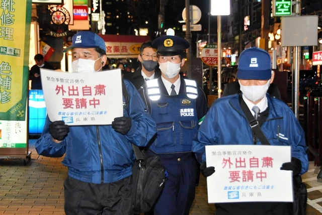 兵庫県の客引き行為等防止指導員に同行して外出自粛を訴える警察官（中央）＝神戸市中央区
