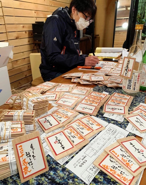 客の願い事を木札に書き込む作業＝酒のてらむら
