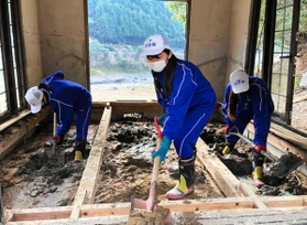 被災家屋の床下に入り込んだ泥をスコップで片付ける生徒たち＝２０２０年１２月２日、熊本県八代市坂本町（秀岳館高校提供）