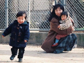 元気に駆け回る生前の将ちゃん（左）。その姿を見守る高井千珠さんと長女（高井さん提供）