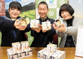 共同開発した炊き込みご飯の缶詰「のどぐろ飯」と「ほたるいか飯」をＰＲする（左から）香住高の北垣心望さん、西垣俊兵さんと但馬漁協職員＝兵庫県香美町香住区若松
