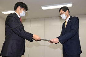 「教員間ハラスメント事案に係る再発防止検討委員会」の川上泰彦委員長（左）から報告書を受け取る長田淳神戸市教育長＝２７日午前、神戸市中央区東川崎町１、神戸市教委（撮影・斎藤雅志）