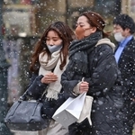 吹雪のように舞う雪の中を寒そうに歩く人たち＝８日午後、神戸市中央区三宮町３（撮影・秋山亮太）