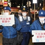 兵庫県の客引き行為等防止指導員に同行して外出自粛を訴える警察官（中央）＝神戸市中央区