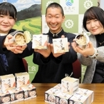 共同開発した炊き込みご飯の缶詰「のどぐろ飯」と「ほたるいか飯」をＰＲする（左から）香住高の北垣心望さん、西垣俊兵さんと但馬漁協職員＝兵庫県香美町香住区若松