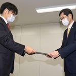 「教員間ハラスメント事案に係る再発防止検討委員会」の川上泰彦委員長（左）から報告書を受け取る長田淳神戸市教育長＝２７日午前、神戸市中央区東川崎町１、神戸市教委（撮影・斎藤雅志）