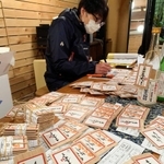 客の願い事を木札に書き込む作業＝酒のてらむら