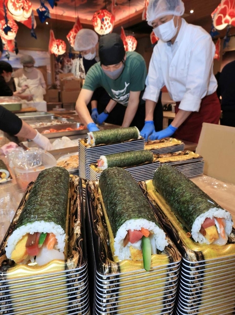 色とりどりの食材を組み合わせた恵方巻きを作るスタッフ＝２日午前、神戸市中央区北長狭通１