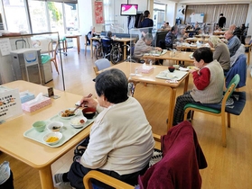 これまで感染者を出していない由良総合福祉センター。感染防止のため、デイサービスの利用者は仕切り板が置かれた机で食事をする＝洲本市由良