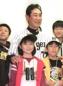 父の形見の帽子をかぶり、故星野仙一監督に肩を抱かれる小島汀さん＝２００２年４月、甲子園球場