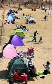 広場を縁取るテント。密を避けて遊ぶ家族の歓声が響く＝神戸市北区しあわせの村