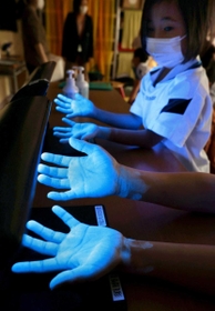 青白く光る子どもたちの手。特殊なライトや液体を使い、正しい手洗いを学ぶ＝神戸市須磨区板宿町１、同市立板宿児童館