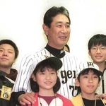 父の形見の帽子をかぶり、故星野仙一監督に肩を抱かれる小島汀さん＝２００２年４月、甲子園球場