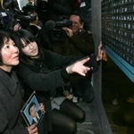 父の名前が刻まれた銘板を見つめる小島汀さん（左から２人目）＝２００９年１２月２０日、神戸市中央区加納町６