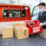 軽トラックの荷台にビール瓶を積み込むすずらん吉田商店の吉田寛さん＝神戸市北区鈴蘭台北町１