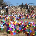 カラフルなかざぐるまが回る中、公園内を散策する行楽客ら＝２１日午後、淡路市夢舞台、国営明石海峡公園（撮影・辰巳直之）