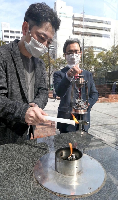 ＨＡＮＤＳの藤本代表理事（左）から「希望の灯り」を受け取る大熊町の幾橋課長＝神戸市中央区加納町６（撮影・小林良多）