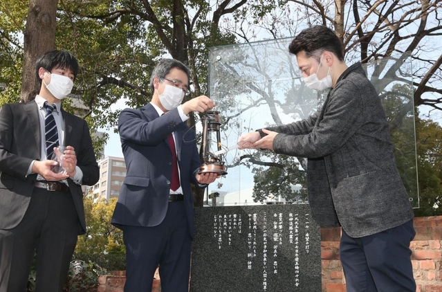 ＨＡＮＤＳの藤本代表理事（右）から「希望の灯り」を受け取る大熊町の幾橋課長＝神戸市中央区加納町６（撮影・小林良多）