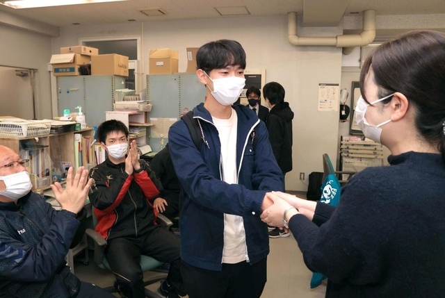 合格の報告に訪れ、教諭たちと喜び合う受験生＝９日午前、神戸市長田区池田谷町２（撮影・吉田敦史）