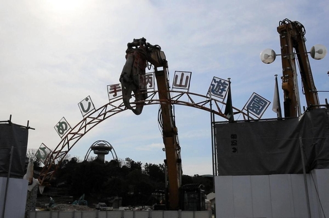 巨大重機で取り外される手柄山遊園の正面ゲート看板＝９日午前、姫路市西延末