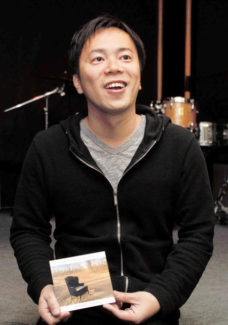 母校で受賞作のアルバムを手に喜びを語る小川慶太さん＝２０１７年３月、神戸市灘区篠原南町５、甲陽音楽学院