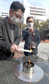 ＨＡＮＤＳの藤本代表理事（左）から「希望の灯り」を受け取る大熊町の幾橋課長＝神戸市中央区加納町６（撮影・小林良多）