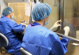 特殊な装置の中で、ワクチンを注射器に分ける職員＝５日午後、神戸市中央区港島南町２、神戸市立医療センター中央市民病院（撮影・小林良多）