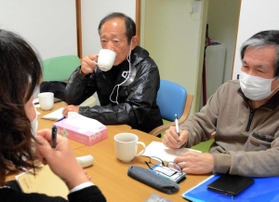 「イロイロ」の定期会合に参加する牧秀一さん（中央）＝大阪府茨木市