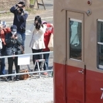 夢中で赤胴車にレンズを向ける鉄道ファンら＝４日午前、西宮市高須町２