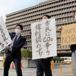 神戸製鋼所の石炭火力発電所増設を巡る訴訟で、大阪地裁の判決後に抗議の意思を表明する原告住民と弁護士たち＝15日午後４時３分、大阪府大阪市北区西天満２