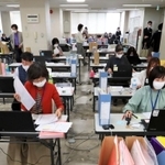 時短要請協力金の申請書類を審査する事務局のスタッフ＝２２日午前、神戸市中央区（撮影・大森　武）