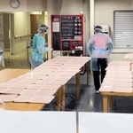 防護服を着て食事の配膳準備をする病院職員＝加古川市平岡町新在家、東加古川病院（同病院提供）