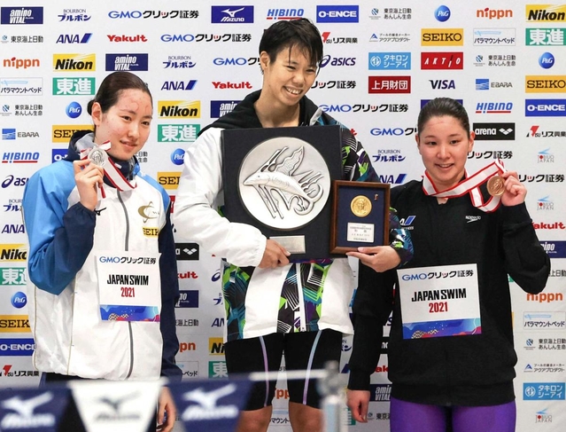 女子１００メートル背泳ぎで優勝した小西杏奈（中央）。左は２位の酒井夏海、右は３位の赤瀬紗也香＝東京アクアティクスセンター