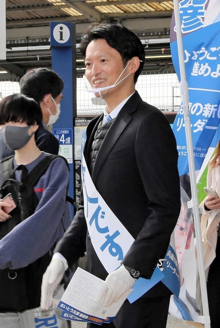 ＪＲ須磨駅前でＰＲのチラシを持って駅前に立つ斎藤元彦氏＝１６日午前、神戸市須磨区