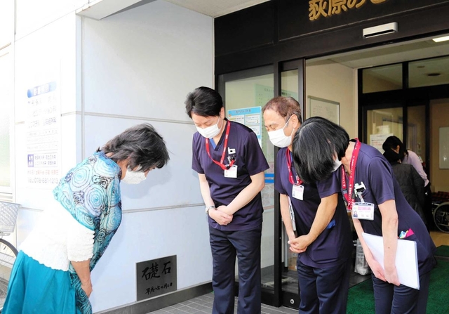 退院時、病院スタッフに頭を下げる女性＝１９日午前、神戸市兵庫区切戸町、荻原みさき病院