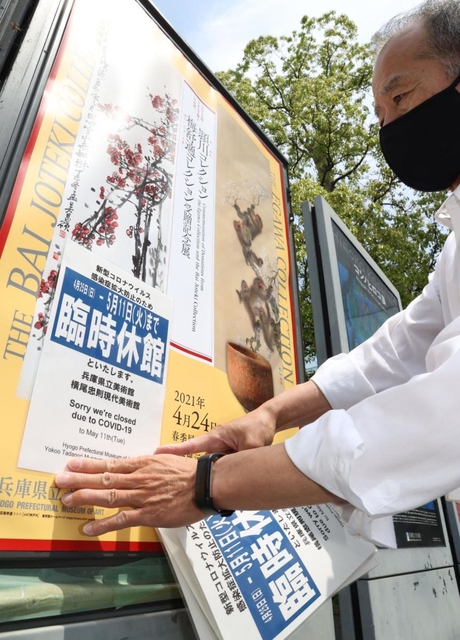 緊急事態宣言に伴う臨時休館の告知を掲示する兵庫県立美術館の職員ら＝２４日午後、神戸市中央区脇浜海岸通１（撮影・吉田敦史）